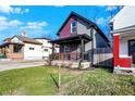 Two-story house with gray and burgundy exterior, American flag, and fenced yard at 635 N Parker Ave, Indianapolis, IN 46201