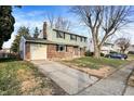 Two-story house with a brick and siding exterior, driveway, and mature trees in front at 2710 Pawnee Dr, Indianapolis, IN 46229