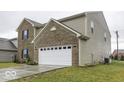 Side view of a two-story house showcasing a white garage door and a neat lawn at 2539 Shadowbrook Trce, Greenwood, IN 46143