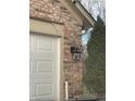 Brick garage with a white door and black lantern light at 2914 Rothe Ln, Indianapolis, IN 46229