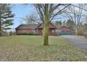 Log cabin home with attached two-car garage at 5360 N Carroll Rd, Indianapolis, IN 46235