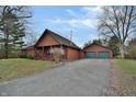 Log cabin home with a two-car garage and driveway at 5360 N Carroll Rd, Indianapolis, IN 46235