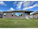 Brick home's back elevation, showcasing a spacious yard at 5375 E Commons West Dr, Mooresville, IN 46158