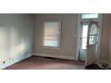 Empty living room with carpet, window, and door at 604 Lincoln St, Indianapolis, IN 46203