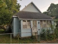 Light blue house with a gabled roof and screened porch at 517 E 7Th St, Anderson, IN 46012