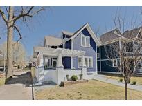 Charming two-story blue home with white trim and a pergola-covered porch at 412 W 11Th St, Anderson, IN 46016
