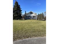 Blue house with large yard and mature trees at 6104 Madison Ave, Indianapolis, IN 46227