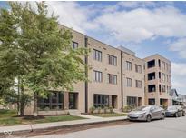 Three-story building with multiple units, landscaping, and street parking at 319 E 16Th St # 207, Indianapolis, IN 46202