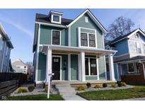Two-story craftsman home with a teal exterior, white trim, and a welcoming front porch at 2133 N Talbott St, Indianapolis, IN 46202