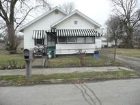 White house with black and white awning, chain link fence, and small front yard at 1310 E 5Th St, Muncie, IN 47302