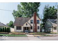 Full exterior view of a charming two-story house with a brick chimney and well-maintained lawn at 819 E 49Th St, Indianapolis, IN 46205