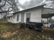 White house exterior showing significant damage at 904 N Penn St, Muncie, IN 47303