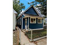 Newly renovated blue house with a chain link fence and small front yard at 221 Kansas St, Indianapolis, IN 46225