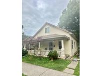 Cute yellow house with front porch and small yard at 212 Hancock Ave, Indianapolis, IN 46222