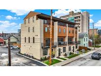 Three-story modern townhouse with wood and brick exterior, balconies, and landscaping at 527 E North St, Indianapolis, IN 46204
