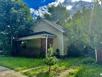 One-story house needing repairs, featuring a brick base and covered porch at 642 N Oxford St, Indianapolis, IN 46201