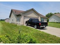 Tan brick ranch home with a black truck parked in the driveway at 1096 Bumblebee Way, Greenfield, IN 46140