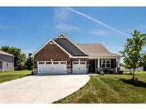 Brick front home with 3-car garage and landscaped lawn at 7813 Fairwood Blvd, Plainfield, IN 46168