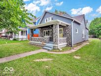 Charming gray house with stone accents and a well-manicured lawn at 3159 Boulevard Pl, Indianapolis, IN 46208