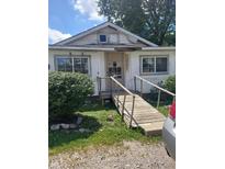 Front view of a modest house with a wooden ramp and landscaping at 2220 S Burke St, Indianapolis, IN 46231