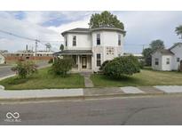 Two-story house with a wrap-around porch and mature landscaping at 401 S Walnut St, Edinburgh, IN 46124