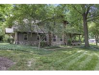 Log cabin home with lush landscaping and stone accents at 2705 S 975 E, Zionsville, IN 46077