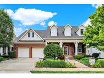 Brick house with a two-car garage and landscaped yard at 15482 Bridgewater Club Blvd, Carmel, IN 46033