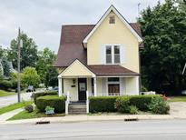 Yellow house with brown roof and landscaping at 202 N State St, Greenfield, IN 46140