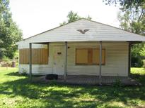 White house with boarded windows and porch at 3321 S Rybolt Ave, Indianapolis, IN 46221