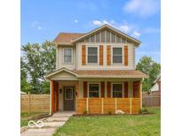 Two-story house with beige siding, brown shutters, and a wooden fence at 4513 Norwaldo Ave, Indianapolis, IN 46205