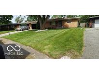 Brick ranch home with a large green lawn and driveway at 4013 N Audubon Rd, Indianapolis, IN 46226