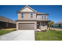Two-story brick home with a brown garage door and landscaped lawn at 1402 Foxtail Ln, Greenwood, IN 46143
