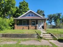 Brick and gray sided home with a covered porch at 2221 Langley Ave, Indianapolis, IN 46218