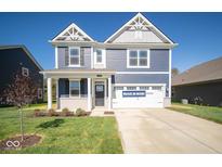 Two-story home with a blue exterior, two-car garage and landscaping at 1678 Orchard Dr, Fortville, IN 46040