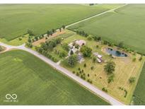 Aerial view of a farmhouse with a pond and expansive farmland at 14733 E 266Th St, Arcadia, IN 46030