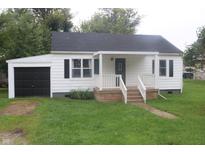 White house with black garage door and porch at 2312 E 22Nd St, Muncie, IN 47302