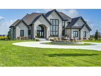 Elegant two-story home with circular driveway and fountain at 9760 Windy Hills Dr, Zionsville, IN 46077