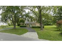 Ranch style home with green lawn and mature trees at 449 Emerson Rd, Carmel, IN 46032