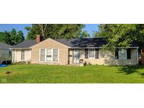 Tan brick ranch house with black shutters and a green lawn at 3536 N Audubon Rd, Indianapolis, IN 46218