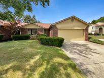 Brick ranch home with attached garage and well-manicured lawn at 8124 Farmhurst Ln, Indianapolis, IN 46236