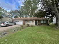 Brick ranch house with a two-car garage and a well-maintained lawn at 9145 Shenandoah Dr, Indianapolis, IN 46229