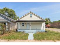 Charming yellow bungalow with light blue steps and walkway at 728 E Beecher St, Indianapolis, IN 46203