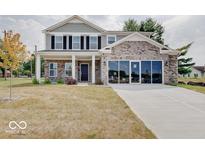 Two story brick home with gray siding and three car garage at 3923 Windstar Way, Columbus, IN 47203