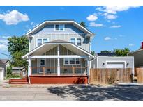 Two-story craftsman home with gray siding, a front porch, and a detached garage at 1938 E 11Th St, Indianapolis, IN 46201