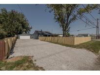 Newly renovated home with gravel driveway and wooden fence at 3730 Prospect St, Indianapolis, IN 46203