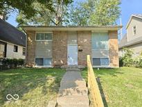 Brick ranch home with a white door and small front yard at 4050 Byram Ave, Indianapolis, IN 46208