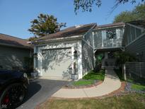 Gray townhouse exterior with a double-car garage and landscaped walkway at 7419 Sylvan Ridge Rd, Indianapolis, IN 46240