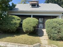 Charming one-story home with a covered porch and well-manicured landscaping at 1108 Burdsal Pkwy, Indianapolis, IN 46208