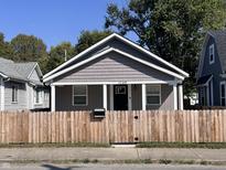 Front view of charming bungalow with gray siding and wooden fence at 1245 N Mount St, Indianapolis, IN 46222