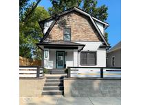 Stunning two-story home with stone and white brick exterior, charming front porch, and modern landscaping at 625 N Temple Ave, Indianapolis, IN 46201